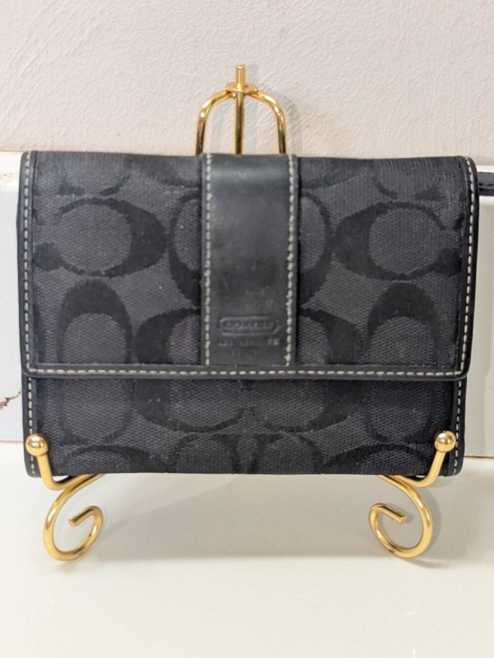Coach black jacquard wallet with leather trim.